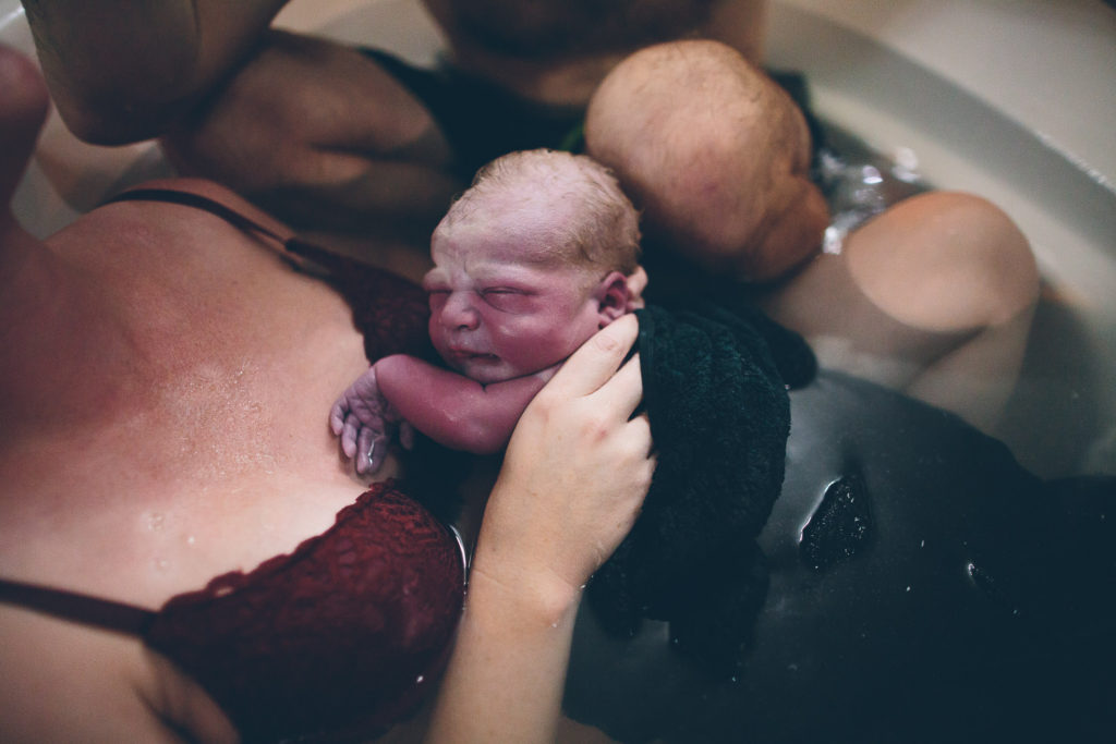 holding baby after home water birth Albany NY birth photography