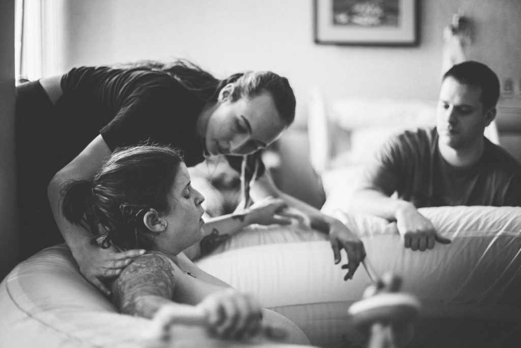 doula helping mom during labor Albany New York birth photography