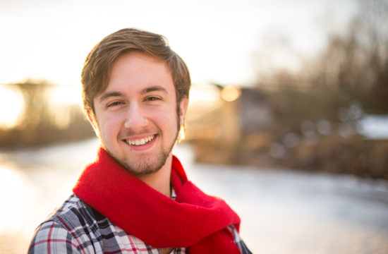 senior boy portrait on frozen river red scarf