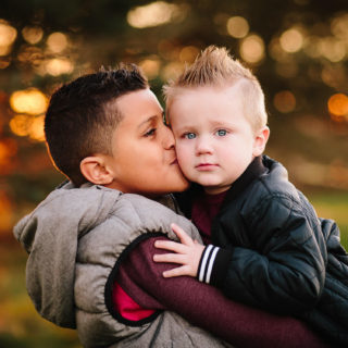 Older brother kissing baby brother Clifton park new York family Photographer