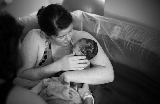 Mom looking at her newborn baby girl right after her home birth