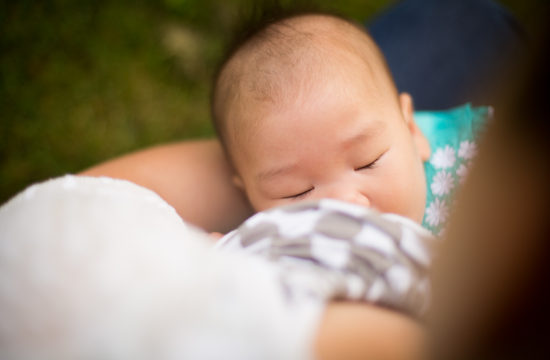 baby girl with long eyelashes nursing to sleep