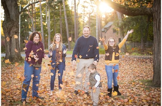 Family playing in fall leaves