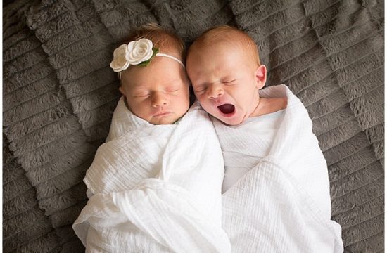 Yawning baby boy sleeping with twin sister