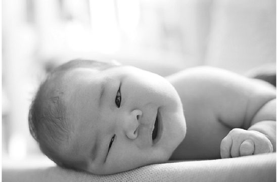 Smiling newborn baby in black and white photo