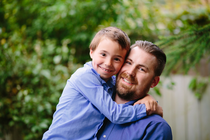 son giving his dad a hug blue shirts