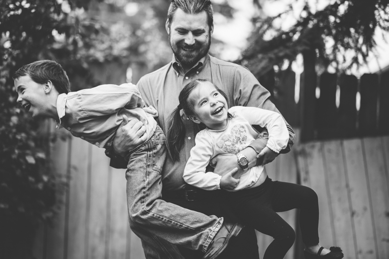 dad holding his two kids laughing