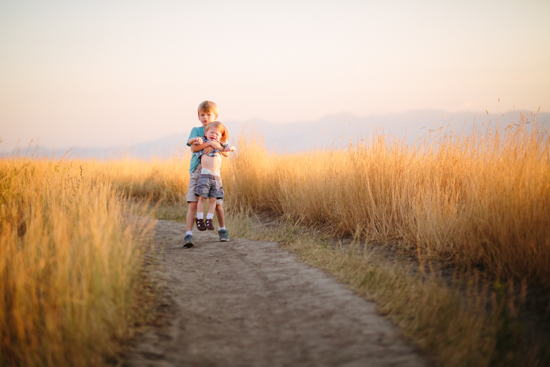 Big brother holding unhappy little brother 