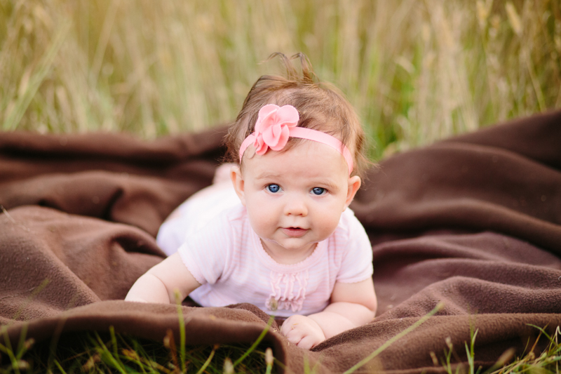 baby girl in a pink dress and pink boy sitting on a blanket