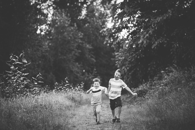 two young boys running on a trail