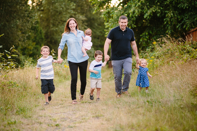 family of 6 running on a trail holding hands