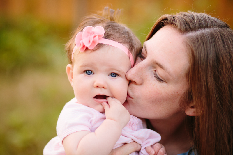 mom kissing the cheek of her baby girl