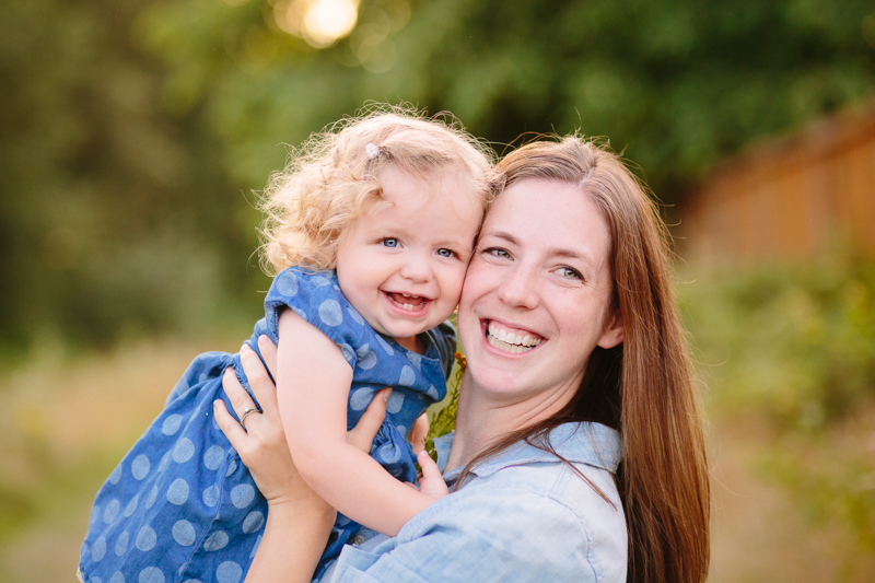 mom holding young daughter 