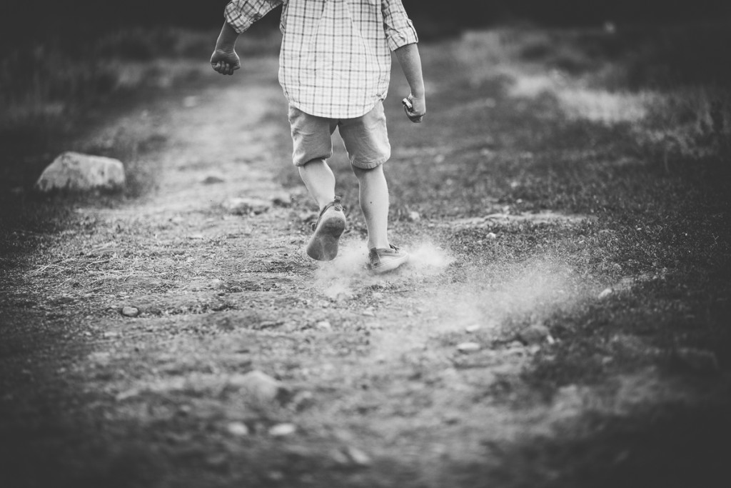 boy feet running on trail kicking up dirt