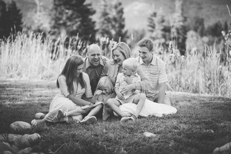 Family of 6 sitting and tickling little girl