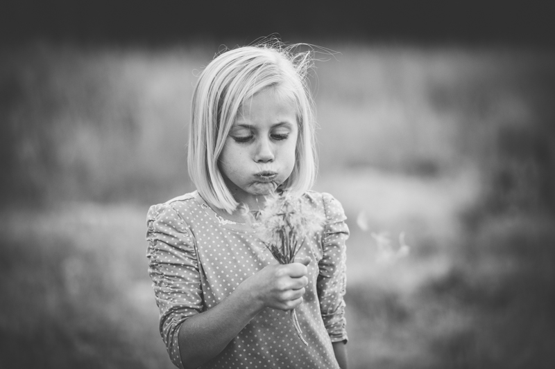 blonde girl blowing dandelion 