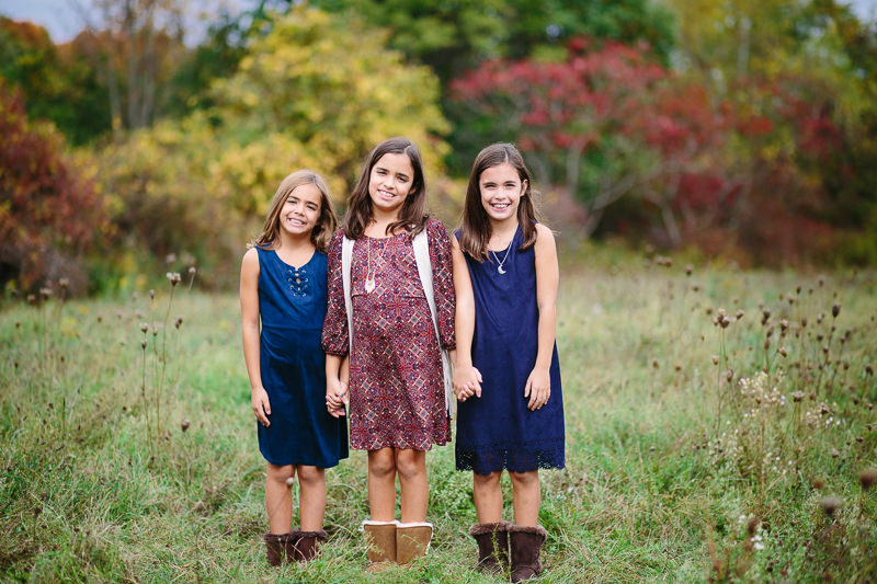 three sisters standing in a field