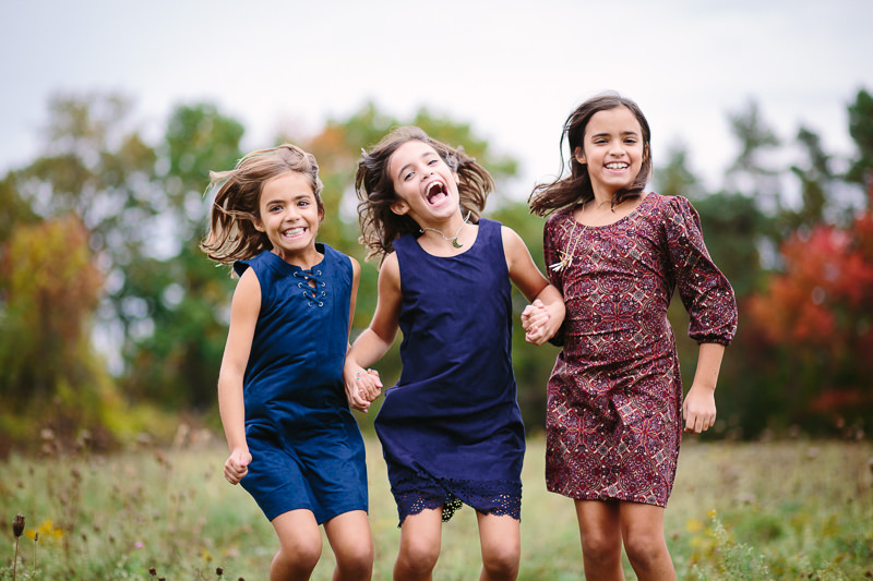 three girls jumping in the air and laughing