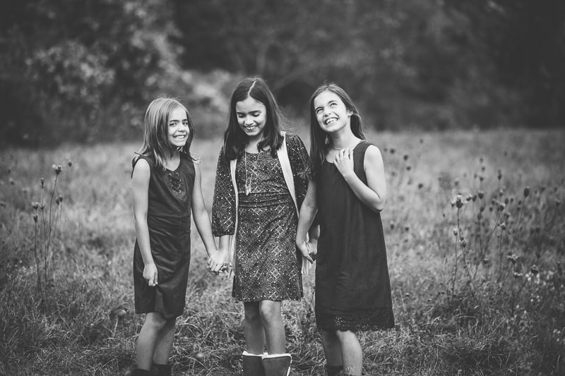 three sisters holding hands and laughing