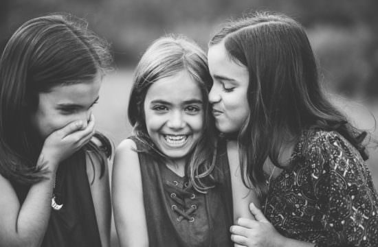 sister giving a kiss and laughing