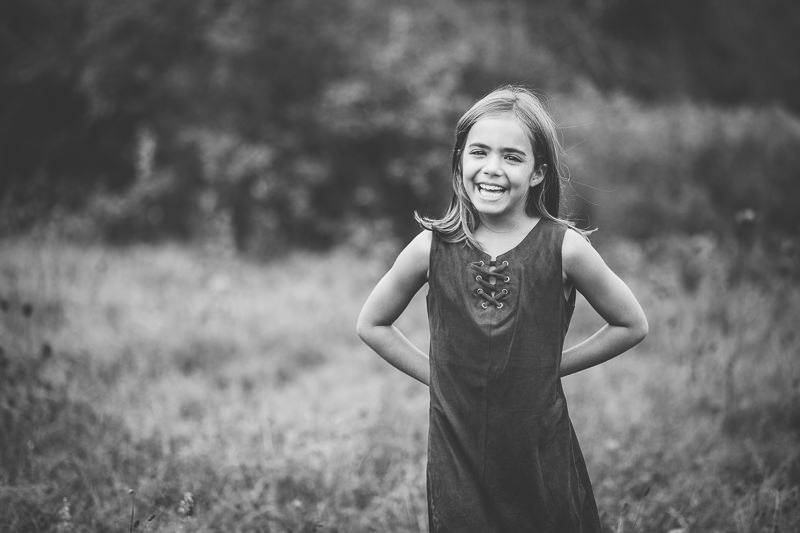 little girl standing with hands behind her back