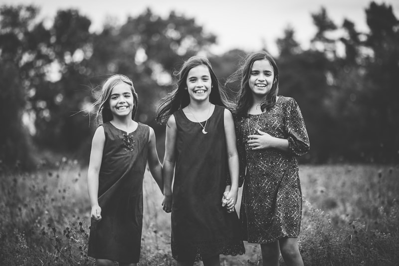 three sisters holding hands wind blowing hair