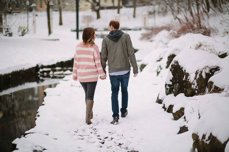 woman in pink sweater holding fiancé hand