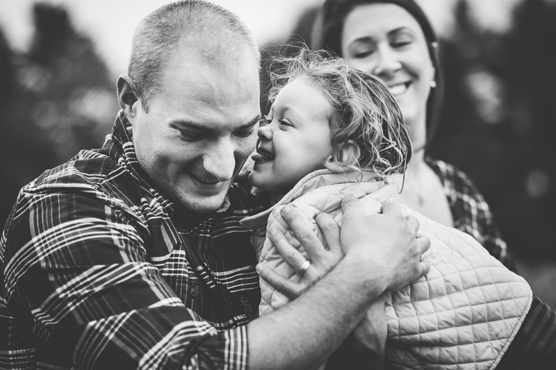 little girl trying to lick dad in black and white