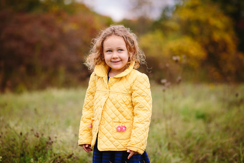 girl with curly hair wearing a yellow jacket