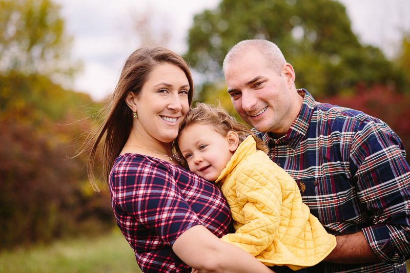 little girl snuggling on moms chest by dad