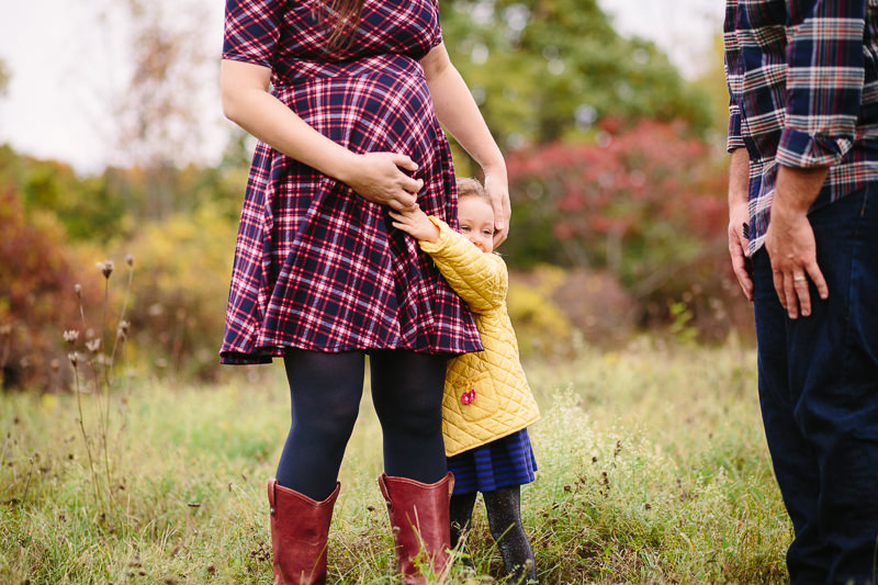 little girl hugging mom's pregnant belly