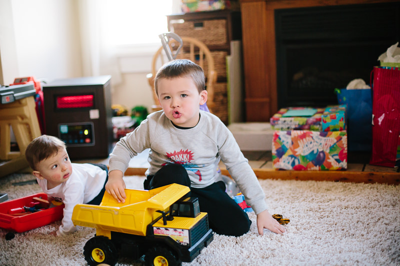 little boy playing with truck and making truck noise