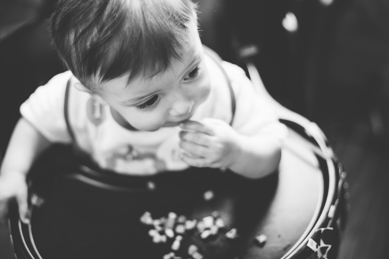 birthday boy eating lunch in high chair