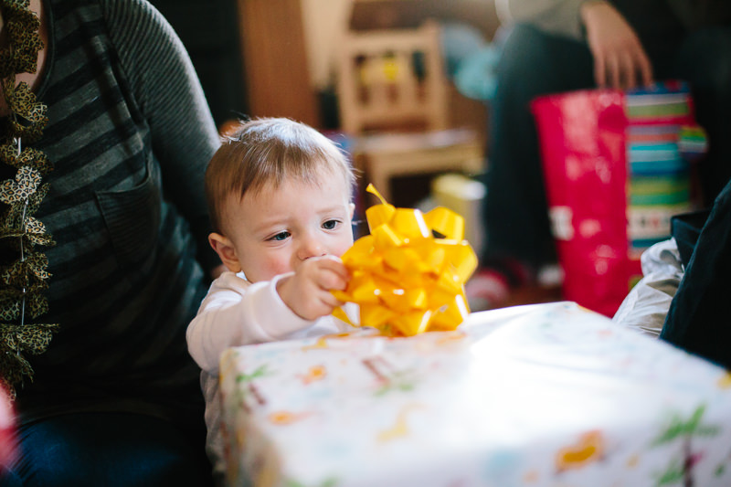 baby boy pulling off bow from present