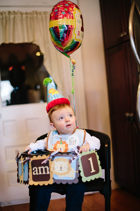 baby boy wearing birthday hat in high chair