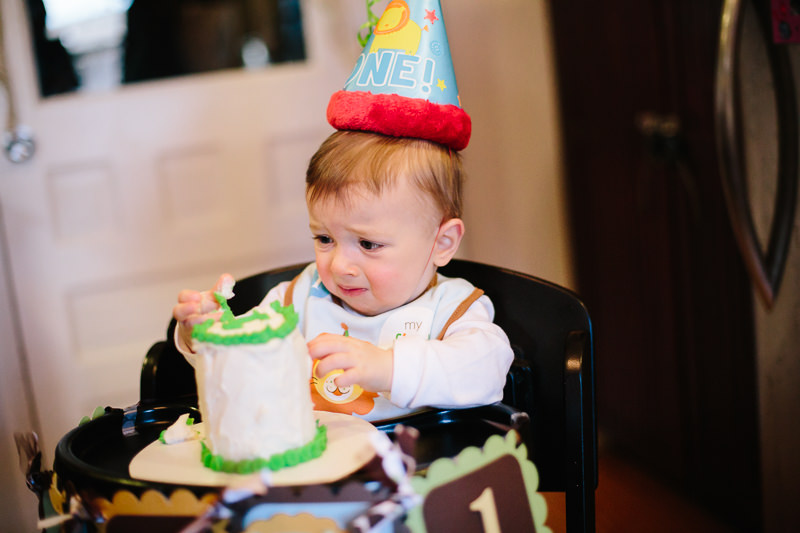 baby boy touching birthday cake