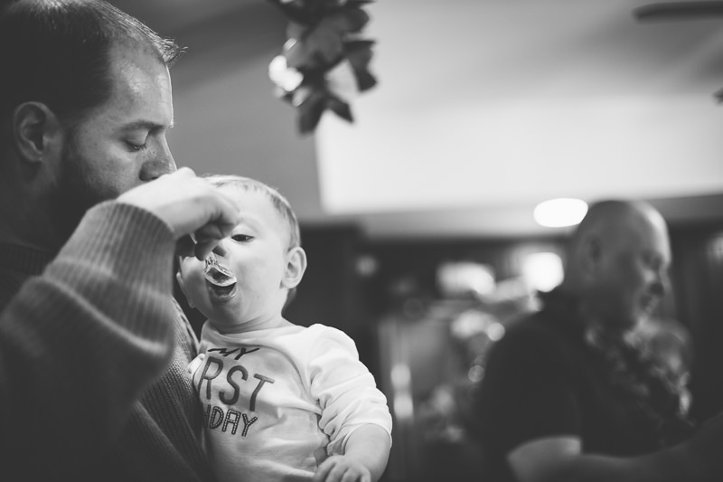 dad feeding baby boy cake on a spoon