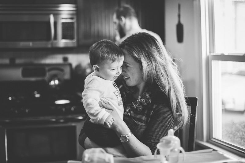 mom snuggling baby boy at the table