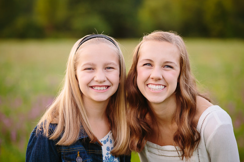 Sisters standing close in a field 