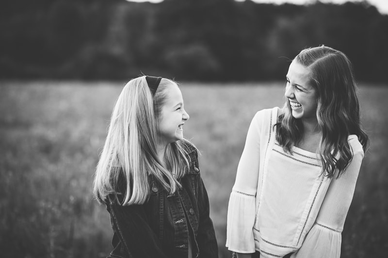 Sisters laughing at each other black and white
