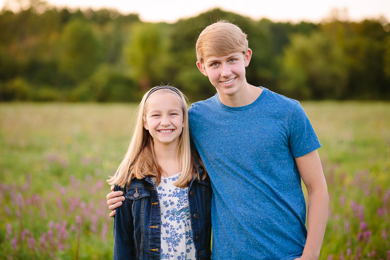 brother with his arm around little sister
