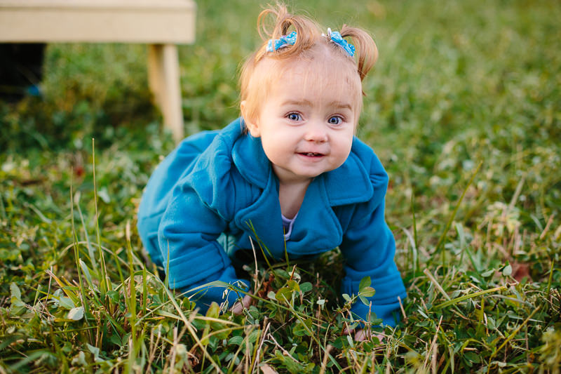 baby girl in teal coat and pig tails