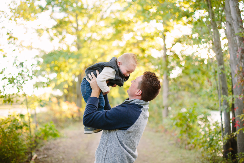 dad holding up baby boy above head