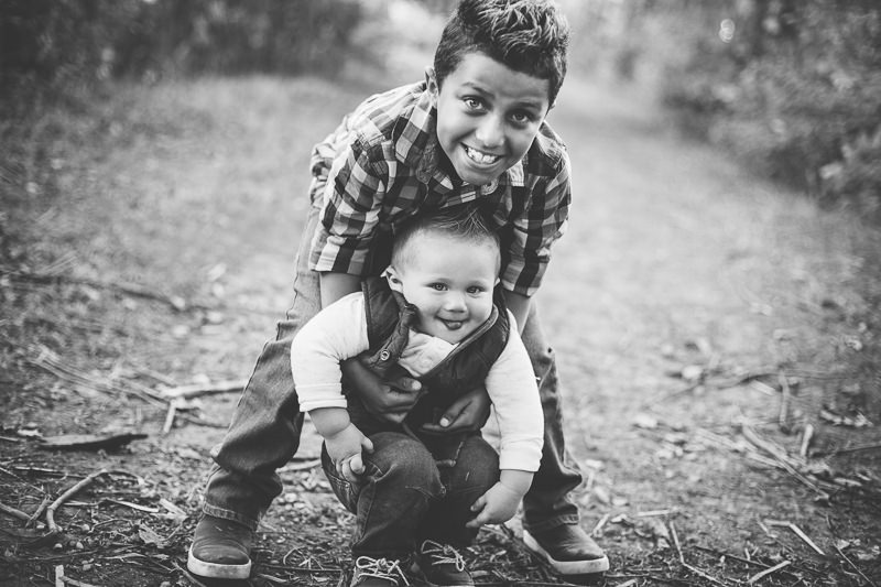 older brother trying to hold baby brother