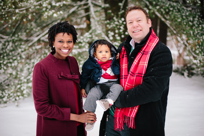 mom dad and baby outside in snow