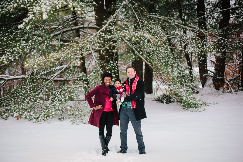 family of three standing outside in snow