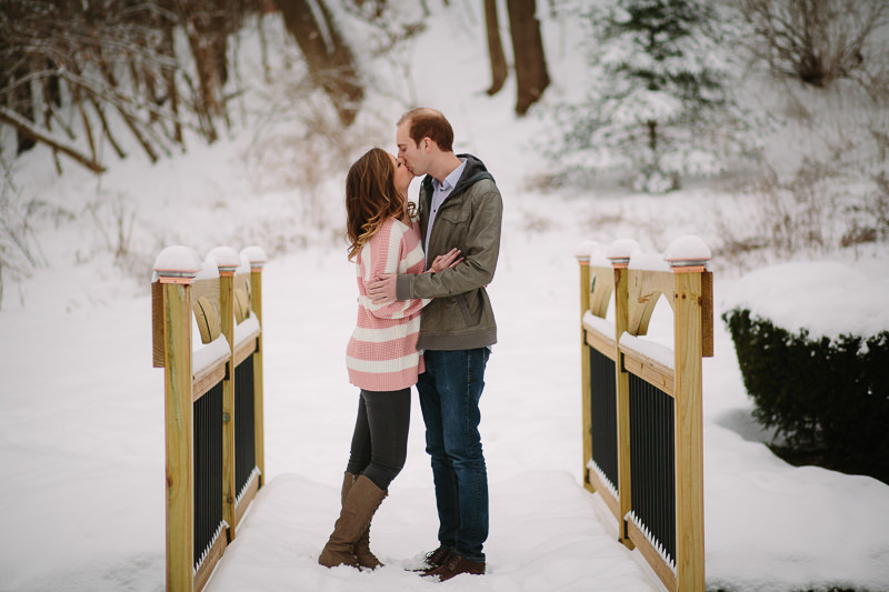 young couple standing snuggling and kissing