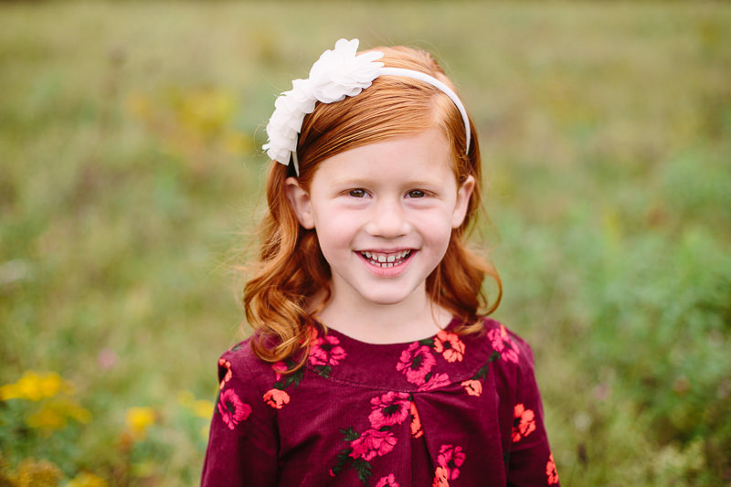 young child with red hair and white bow