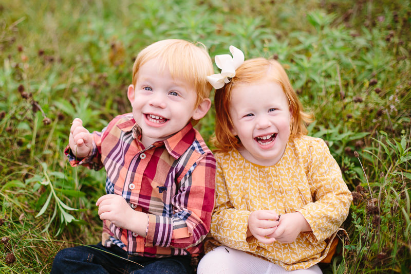 toddler twin boy and girl sitting and laughing