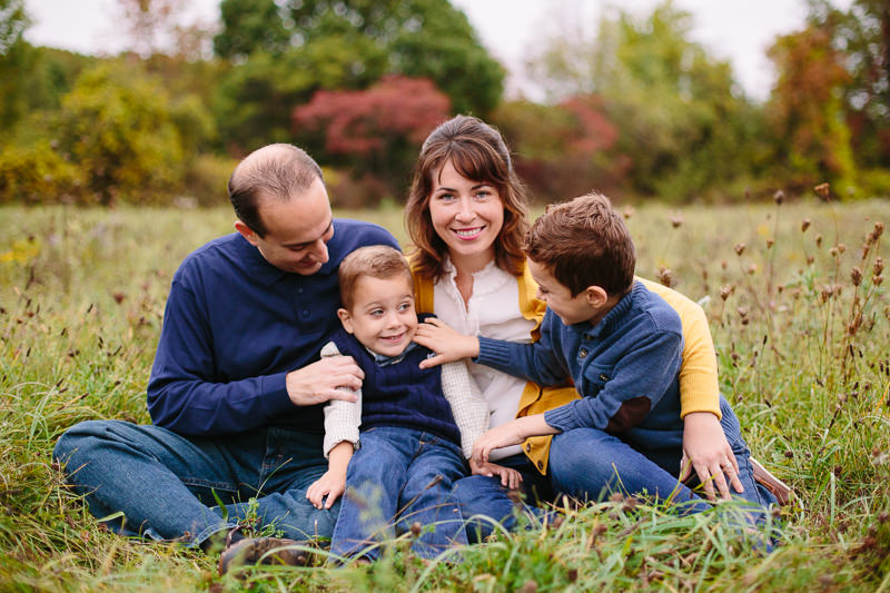 family of four tickling little brother